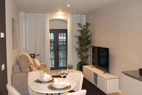 a living room with a couch and a table and a tv at Apartamentos Catedral III in Valladolid