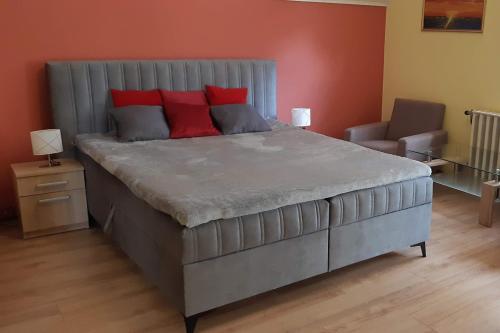 a large bed with red pillows in a bedroom at Villa Mariella in Siófok
