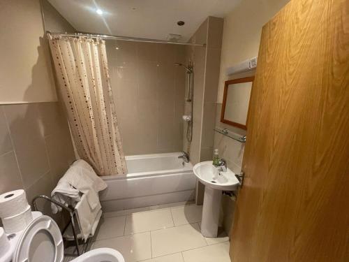 a bathroom with a toilet and a tub and a sink at 3 Bed Hse Esker Hills Golf Club 018 in Ballynasrah