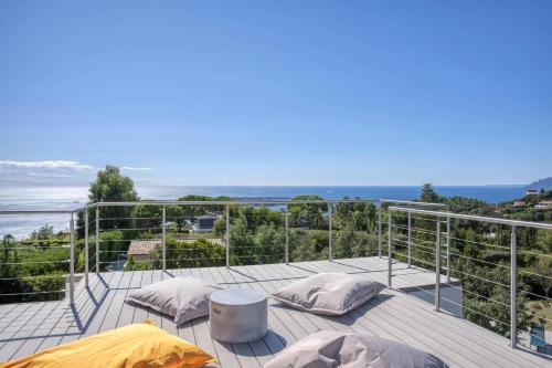 d'un balcon avec des oreillers et une vue sur l'océan. dans l'établissement Beautiful 5 bedroom villa with sea view & pool, à Vallauris