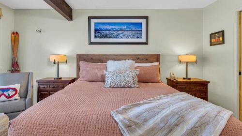 a bedroom with a large bed with two night stands and two lamps at Meadow House - Unit 56 in Sunriver