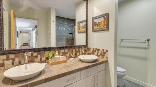 a bathroom with two sinks and a toilet and a mirror at Meadow House - Unit 56 in Sunriver