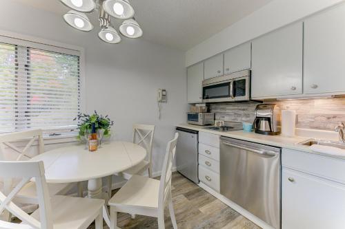 a kitchen with a white table and a table and chairs at Gorgeous Chic Beach Front Condo 2775 in Traverse City