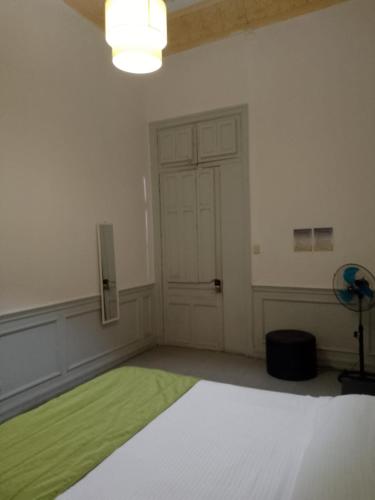 an empty room with a green rug in front of a door at Happy House Hostel in Santiago