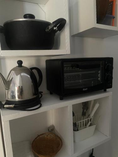 a microwave sitting on a shelf in a kitchen at Departamento A&F II 1er piso Monoambiente 4 personas in San Fernando del Valle de Catamarca