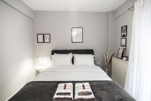 a bedroom with a large bed with two towels on it at Hermes Modern Apartment in Alexandroupoli