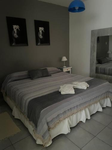 a large bed in a bedroom with two pictures on the wall at Departamento A&F II 1er piso Monoambiente 4 personas in San Fernando del Valle de Catamarca