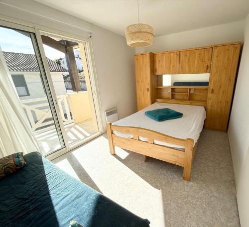 une chambre avec un lit et une grande fenêtre dans l'établissement Douceur Océane Terrasse & Balcon, à Mimizan-Plage