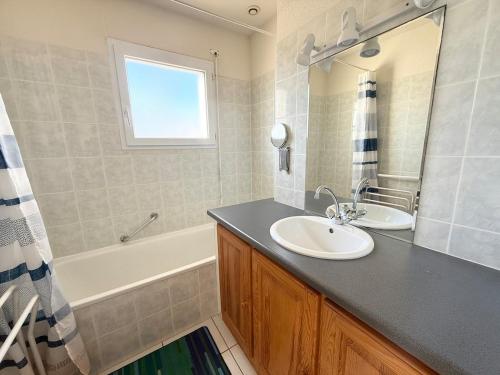 une salle de bain avec un lavabo et une baignoire dans l'établissement Douceur Océane Terrasse & Balcon, à Mimizan-Plage