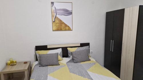 a bedroom with a bed and a table and a picture at Positive Apartment in Petrich