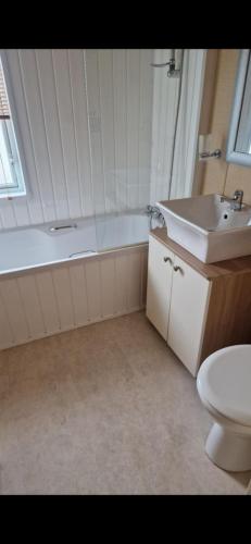 a bathroom with a tub and a sink and a toilet at Coastal Retreat Lodge in Morecambe