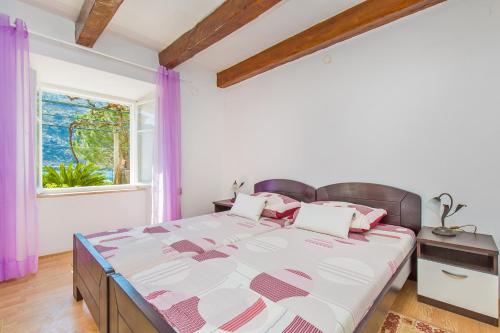 sypialnia z dużym łóżkiem i oknem w obiekcie Apartman Monkovic w mieście Mokošica