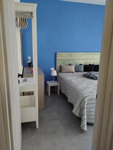 a bedroom with a bed and a blue wall at Appartamento Mare Blu in Martinsicuro