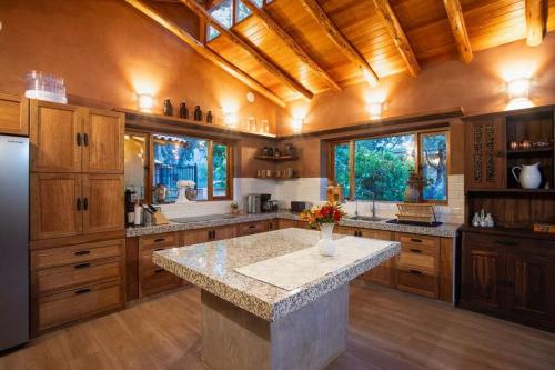 a large kitchen with wooden cabinets and a large island at Stunning 1BR House in Camino Real in Urubamba