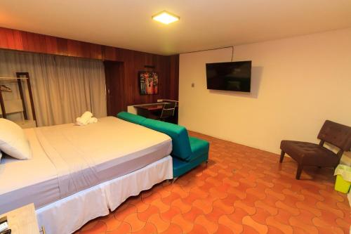 a hotel room with a bed and a television at Casa Lomas in Tegucigalpa