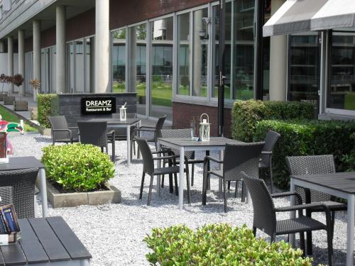 a group of tables and chairs in front of a building at Garner Hotel Maastricht by IHG in Maastricht