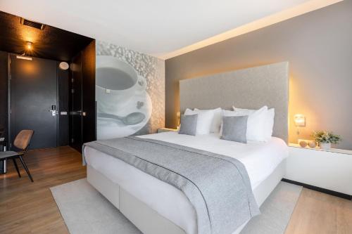 a bedroom with a large white bed in a room at Garner Hotel Maastricht by IHG in Maastricht