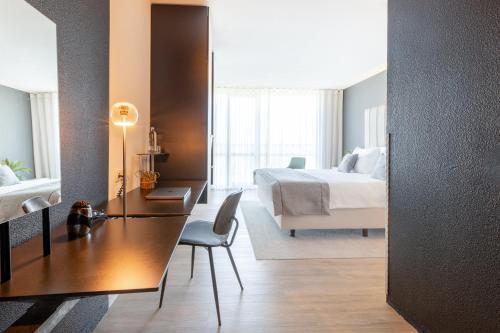 a hotel room with a bed and a desk and a bedroom at Garner Hotel Maastricht by IHG in Maastricht