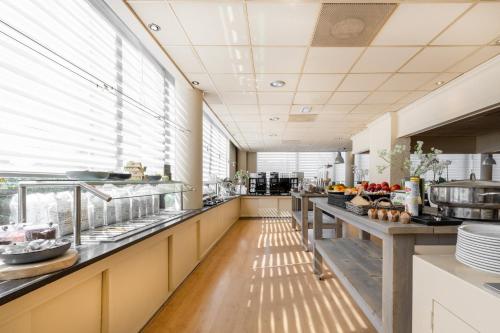 a large kitchen with a long line of counters at Garner Hotel Maastricht by IHG in Maastricht