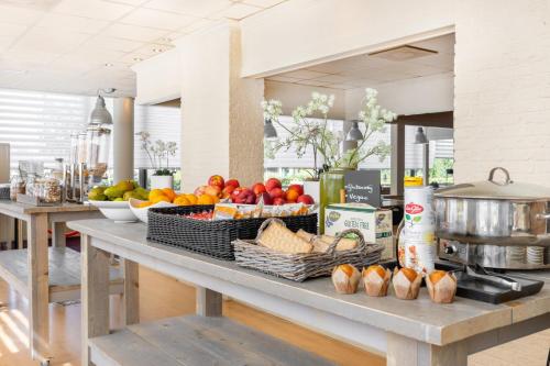 a counter with baskets of fruits and vegetables on it at Garner Hotel Maastricht by IHG in Maastricht