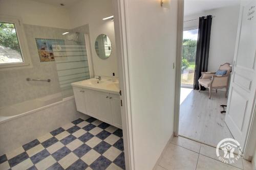 a bathroom with a tub and a sink and a mirror at Mathilde in Lannion