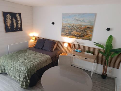 une petite chambre avec un lit et une table dans l'établissement STUDIO CALME PROCHE CENTRE BORDEAUX, à Bordeaux