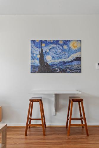 two stools in a room with a painting on the wall at Stylish North Melbourne Stay, Minutes to CBD in Melbourne