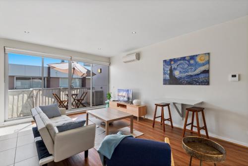 a living room with a couch and a table at Stylish North Melbourne Stay, Minutes to CBD in Melbourne