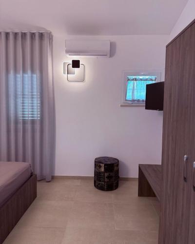 a white room with a bed and a television at Relais San Giovanni srls in Castellaneta