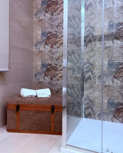 a shower stall with two towels on a wooden chest at Relais San Giovanni srls in Castellaneta