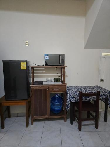 a room with a table with a microwave and a television at Casa Donaji in Oaxaca City