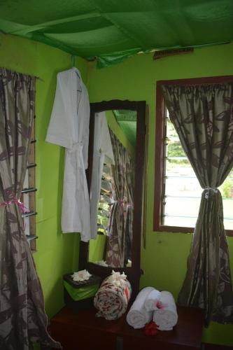 a green room with a mirror and some towels at Jima's Home Retreat in Matei