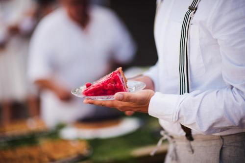 a person holding a piece of cake on a plate at Björkebo Camping in Stöllet