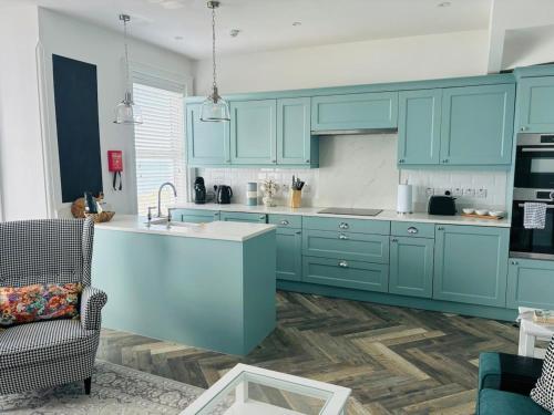 a kitchen with blue cabinets and a sink at Seascape Luxury sea front apartment in Bangor