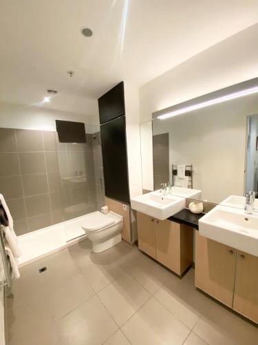 a bathroom with two sinks and a toilet and a tub at Knights' Retreat Napier in Napier