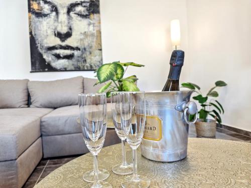 a bottle of wine in a bucket on a table with glasses at Designer Loft für bis zu 15, Whirlpool, Infrarotsauna, Billard, Pokertisch, 2 Bäder in Nürnberg