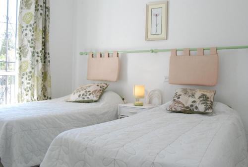 um quarto com 2 camas e uma janela em Los Pinos 25 Villas Casasol em Nerja