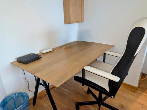 une table en bois avec une chaise noire et blanche dans l'établissement F2 Rouen Centre Gare Boulingrin - possibilité de parking, à Rouen