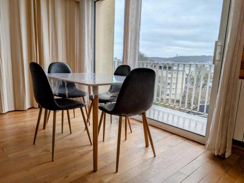 une table et des chaises dans une pièce avec une grande fenêtre dans l'établissement F2 Rouen Centre Gare Boulingrin - possibilité de parking, à Rouen