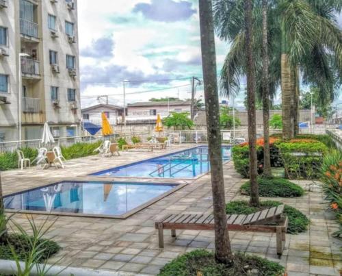 a pool at a hotel with benches and palm trees at condo apartment for rent for cop30, 10 minuto do aeroporto e centro olímpico in Belém