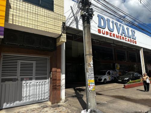 a woman walking in front of a car garage at Apto inteiro com 3 quartos, sendo 1 suite com ar condicionado cidade Nobre in Ipatinga