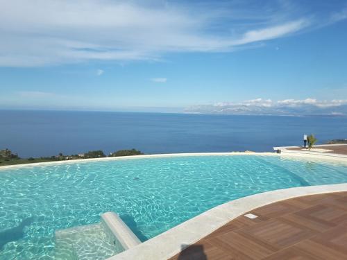 a swimming pool with a view of the water at Hotel Antica Cascina Del Golfo in Scopello