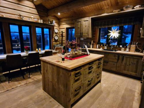 a kitchen with a center island in a cabin at Liaplassen Tømmerhytte in Beitostøl