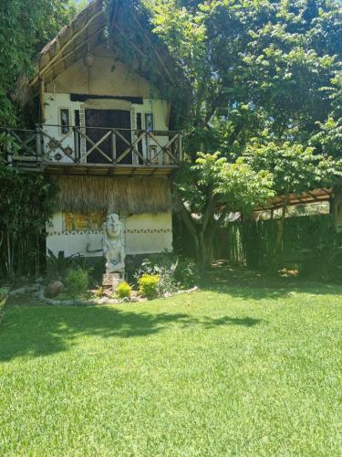a house with a balcony and a fire hydrant in a yard at Eco Hotel Tahawi in Ajijic