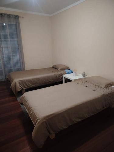 a bedroom with two beds and a table at Lovely apartment in Cascais Park in Cascais