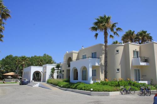 a building with a palm tree in front of it at Andromeda Hotel Apartments in Kos Town