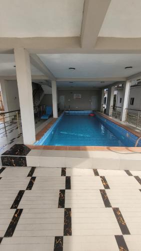 a large swimming pool in a large building at stay at Creo's one bedroom swimming pool and gym in Ibeju