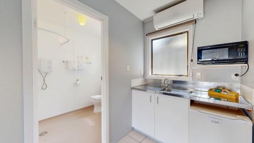 a white bathroom with a sink and a toilet at Albatross Motel in Napier