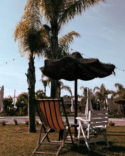 a chair and an umbrella next to a palm tree at Relais San Giovanni srls in Castellaneta