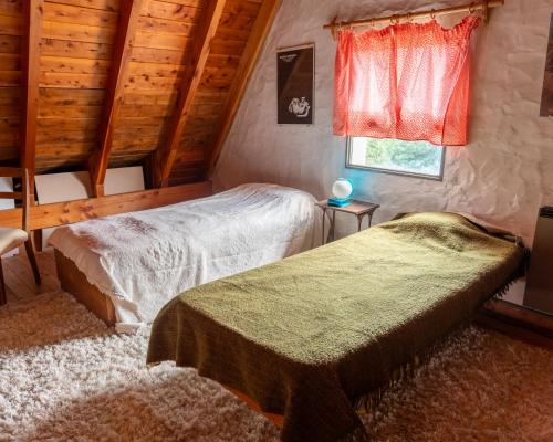 a bedroom with two beds and a window at Casa Vintage in San Carlos de Bariloche